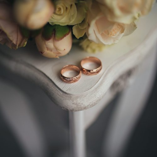 Wedding rings with flowers on the table. High quality photo